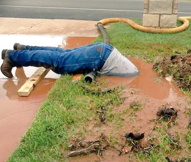 Plumber working inside a drain